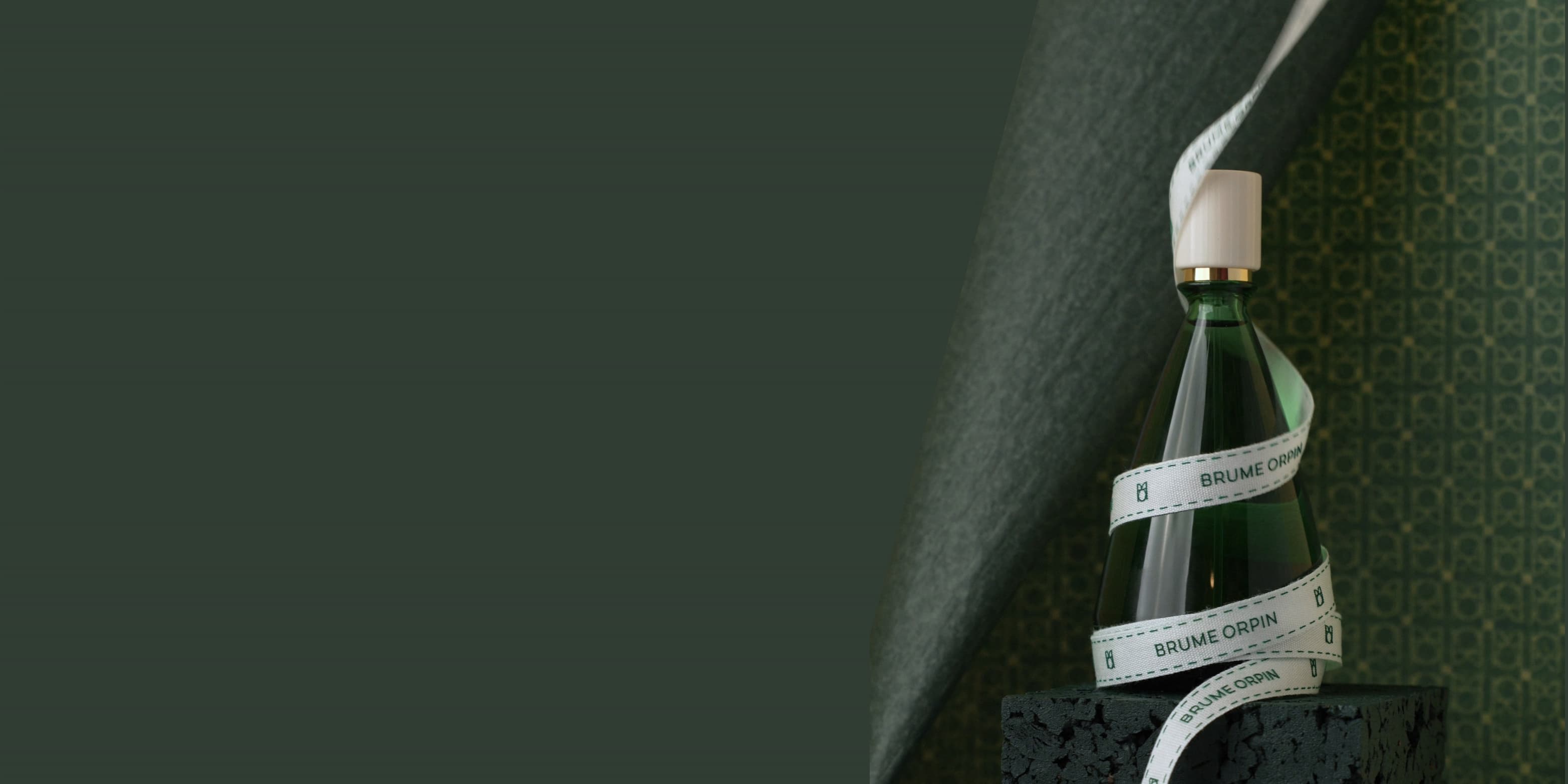 Un flacon BRUME ORPIN entouré d'un ruban blanc BRUME ORPIN