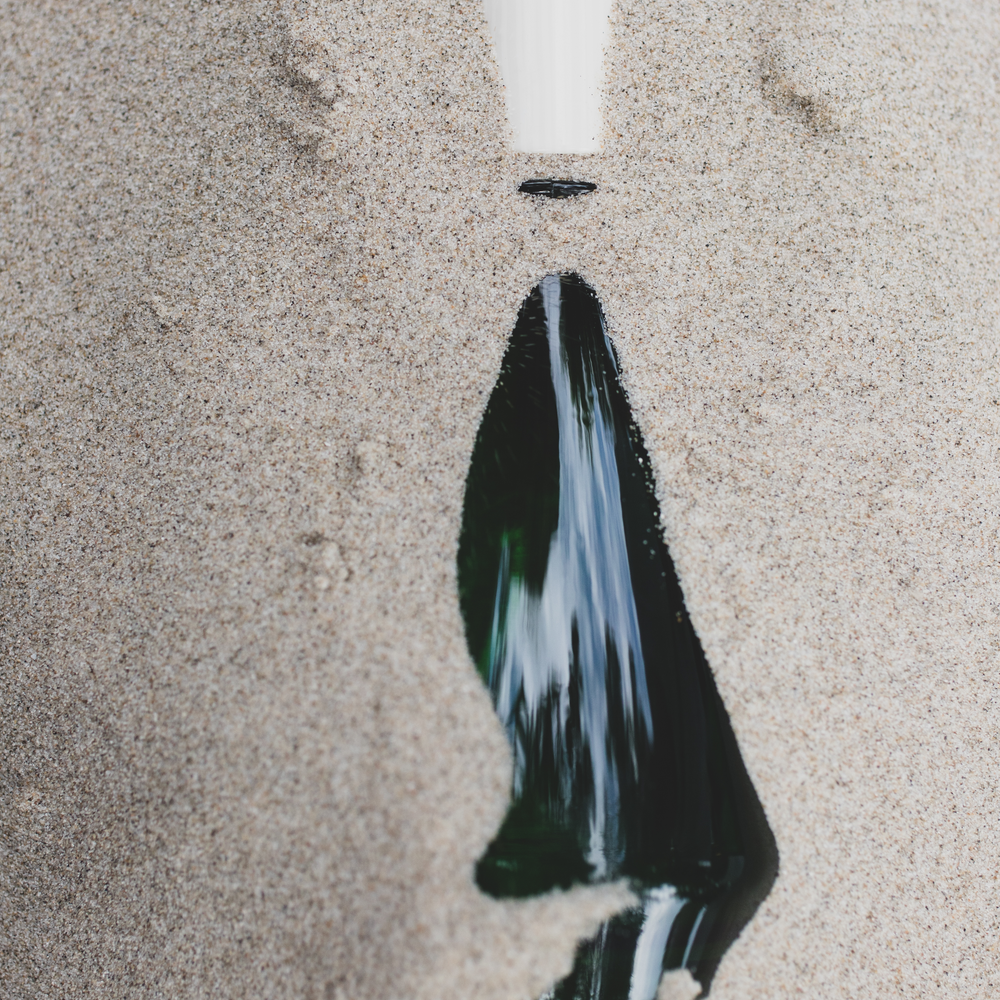 Un flacon BRUME ORPIN dans du sable