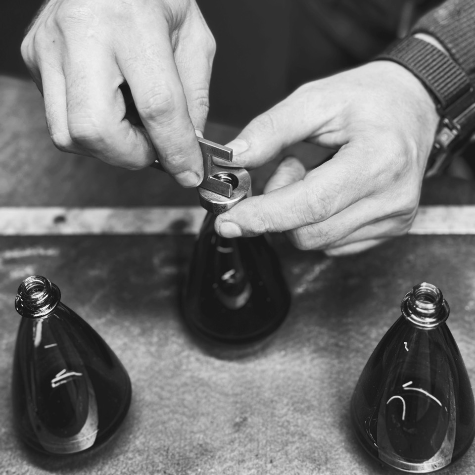 Un artisan travaillant sur un flacon